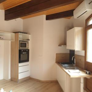 a kitchen with white cabinets and a stove top oven at Appartement Grésival in Chapareillan