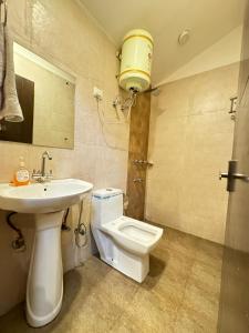 a bathroom with a toilet and a sink at Hotel Height's - Kalka ji in New Delhi