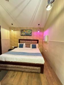 a bedroom with a bed and a pink wall at Hotel Height's - Kalka ji in New Delhi