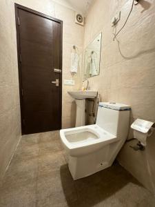 a bathroom with a toilet and a sink at Hotel Height's - Kalka ji in New Delhi