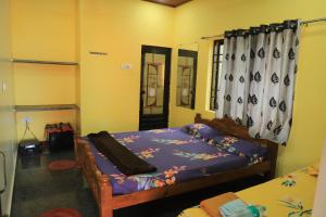 a bedroom with a bed and a window at Ruvi Beach front Ac rooms in Gokarna