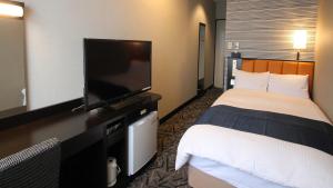 行橋市にあるアパホテル 福岡行橋駅前のベッド1台、薄型テレビが備わるホテルルームです。