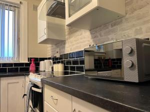 a kitchen with a counter top with a microwave at Spacious Luxury 3 Bedroom Flat in Kirkcaldy, Fife in Fife