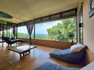 a living room with a couch and a glass table at Villa Montaview Puncak (Mountain View Cottage) in Gadok 1