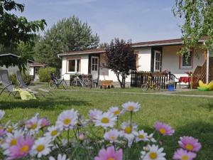 a house with flowers in front of a yard at Seepark Heidenholz Plau am See in Plau am See