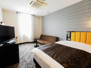 行橋市にあるアパホテル 福岡行橋駅前のベッド1台、薄型テレビが備わるホテルルームです。
