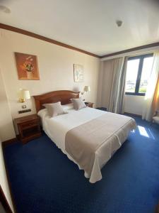 a bedroom with a large bed and a large window at Hotel Villa De Almazan in Almazán