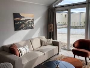 a living room with a couch and a large window at Vakantiepark duinzicht in Koudekerke