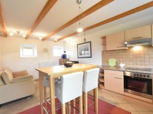 a kitchen with a wooden table and white chairs at Lovely Apartment in Stellshagen with Garden in Stellshagen