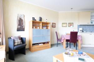 una sala de estar con una mesa y una silla en Kurpark-Residenz App. 217 Seesicht, en Cuxhaven
