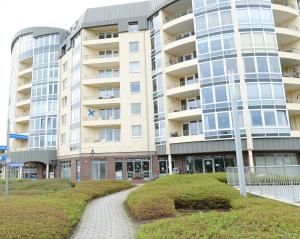 un edificio de apartamentos con una pasarela delante de él en Kurpark-Residenz App. 217 Seesicht, en Cuxhaven