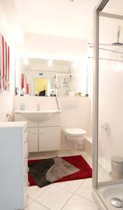 Un baño blanco con lavabo e inodoro. en Kurpark-Residenz App. 217 Seesicht, en Cuxhaven