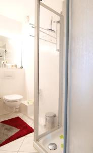 baño con aseo y puerta de ducha de cristal en Kurpark-Residenz App. 217 Seesicht, en Cuxhaven 15 fotos más