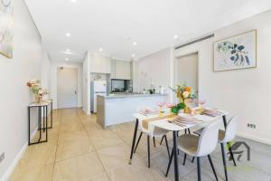 a kitchen and dining room with a table and chairs at Sunshine 2 Bed home in Olympic Park in Sydney