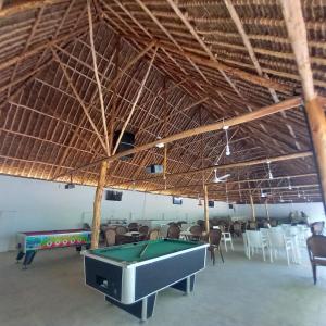 een grote kamer met een pooltafel en stoelen bij Maasai Barracks Resort in Mombasa