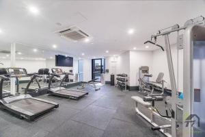 a gym with treadmills and machines in a room at Sunshine 2 Bed home in Olympic Park in Sydney