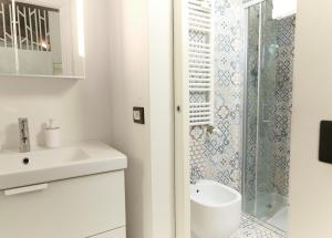 een witte badkamer met een wastafel en een douche bij Central Loft in Milaan