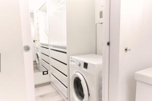 een witte wasruimte met een wasmachine en droger bij Central Loft in Milaan
