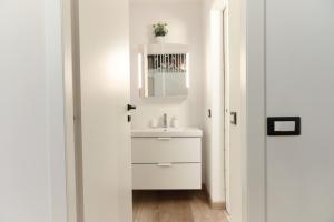 een witte badkamer met een wastafel en een spiegel bij Central Loft in Milaan