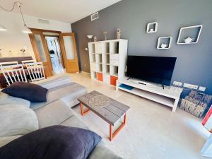 uma sala de estar com um sofá e uma televisão de ecrã plano em A576 - Balcón del Mar - 2004 Finestrat s.l. em Villajoyosa