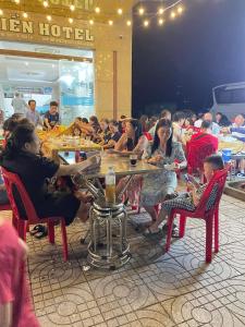 un groupe de personnes assises à table dans un restaurant dans l'établissement Khách sạn Sơn Hiền Cửa Lò, à Cửa Lô