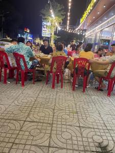 Khách sạn Sơn Hiền Cửa Lò في كوا لو: مجموعة من الناس يجلسون على الطاولات في المطعم في الليل