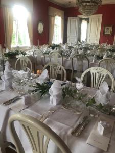 une salle à manger avec des tables et des chaises blanches dans l'établissement Moholms Herrgård, à Moholm
