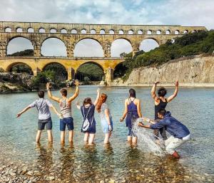 a group of people standing in the water at La Bastide des Pins in Castillon-du-Gard