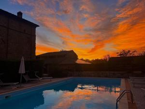 a sunset over a swimming pool at sunset at Antica Torre in Salsomaggiore Terme