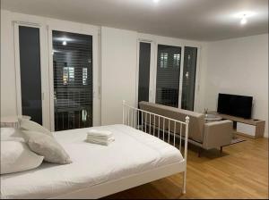 sypialnia z łóżkiem, kanapą i telewizorem w obiekcie Logement spacieux proche de Lausanne w mieście Crissier