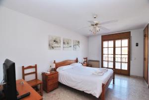 1 dormitorio con 1 cama y TV de pantalla plana en Ca l'Enric, en Cabrera de Mar