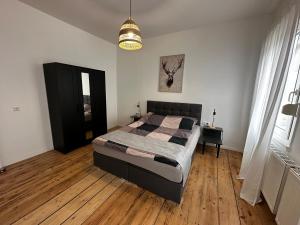 a bedroom with a large bed and a wooden floor at Vintage Apartment 1 am Kurpark von Bad Ems in Bad Ems