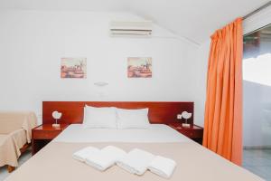 een slaapkamer met een bed met 2 kussens erop bij Haris Hotel in Hanioti