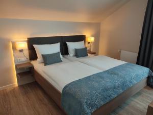 una camera da letto con un grande letto con due cuscini di Hotel Thode a Dahme