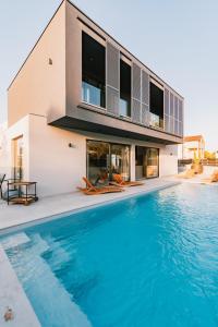 a house with a swimming pool in front of a house at Domina in Vodice
