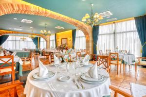 a dining room with tables and chairs with white table linen at Hotel Villa De Almazan in Almazán