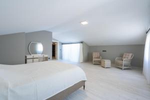 a bedroom with a white bed and two chairs at Villa Tutar 2 in Marmaris