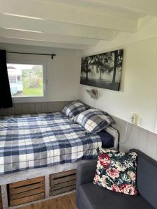 1 dormitorio pequeño con 1 cama y 1 sofá en Pieterwagen, en Sleen