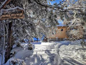 un patio cubierto de nieve con una casa y un cartel en Вила Приказка en Zar-Kalojan