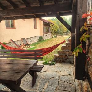 a hammock in a building with a table and benches at Вила Приказка in Tsar Kaloyan