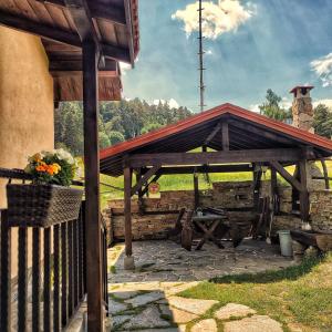 a wooden pavilion with a picnic table in a field at Вила Приказка in Zar-Kalojan