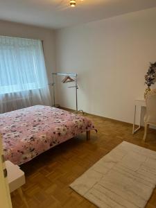 a bedroom with a bed with a pink blanket at 01 quarto de casal Os demais cômodos da casa serão de uso compartilhado in Lucerne