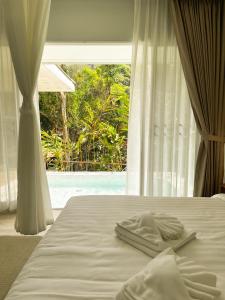 a bed with two towels on it with a window at Arb Pa Home and Cafe @ Mae on in Chiang Mai
