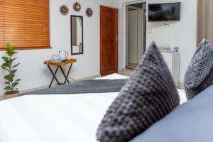 a bedroom with a bed with black and white pillows at The Little Gem in Clanwilliam