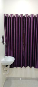 チェンナイにあるSR RESIDENCYのバスルーム(紫色のシャワーカーテン、シンク付)