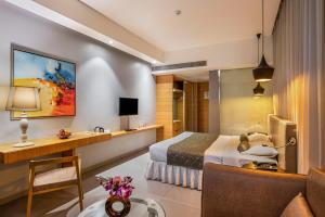 塔那的住宿－薩塔卡爾大酒店，配有一张床和一张书桌的酒店客房