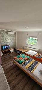 トゥズラにあるApartmani Rokiのベッド2台とテーブルと窓のある部屋