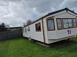 a white tiny house sitting in a yard at Plot 203 paris in Rhyl