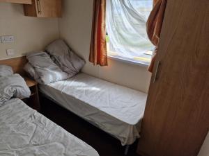 a small room with two beds and a window at Plot 203 paris in Rhyl