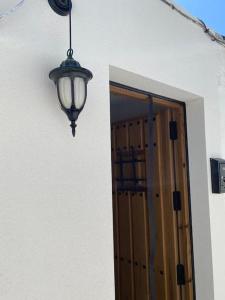 uma luz pendurada num edifício com uma porta em La casita de la abuela María em Almeria